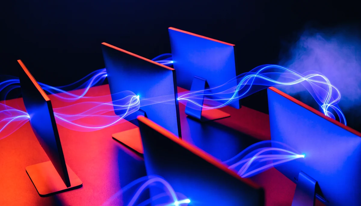 Écrans reliés par des flux lumineux — agents IA qui travaillent en réseau